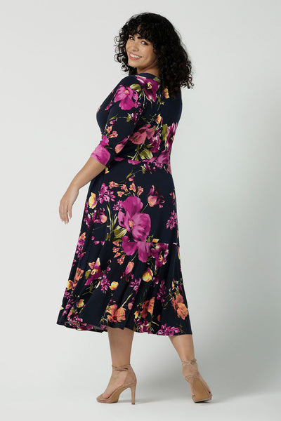 Back view of a size 18 Woman wearing the Bettina Petite Reversible dress the Celeste print. It is a fixed wrap style with pockets and frill detail. A great work to wedding dress for women size 8 - 24.