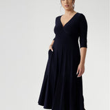 Workwear dress worn by size 10 petite height woman in Navy dry touch jersey. Stylish workwear dresses for women. Midi length with functional pockets, and can be reversed for a choice of v neckline or boat neck. Made in Australia for women size 8 - 24.