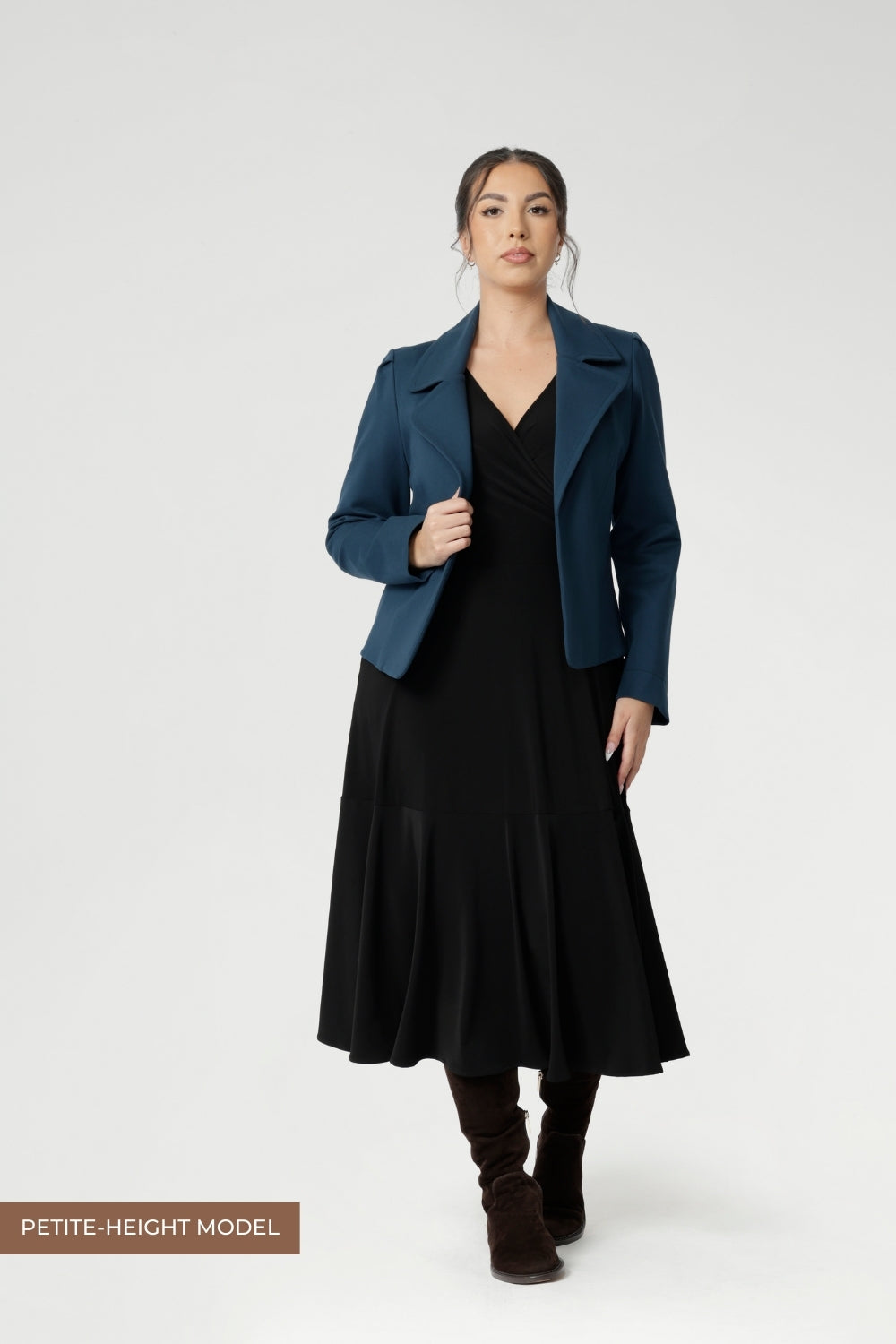 Petite height woman wears Bettina Reversible Dress in Black with petrol coloured jacket. Australian made Jersey fixed wrap dress features a V-neck style with pockets and midi length. Made in Australia with petite height and plus size women in mind. Available in sizes 8-24. 