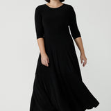 Size 10 woman wears a black reversible dress. Black jersey dress with black heels. Made in Australia for women size 8 - 24. Comfortable easy care jersey. Made in Australia for women size 8 - 24.