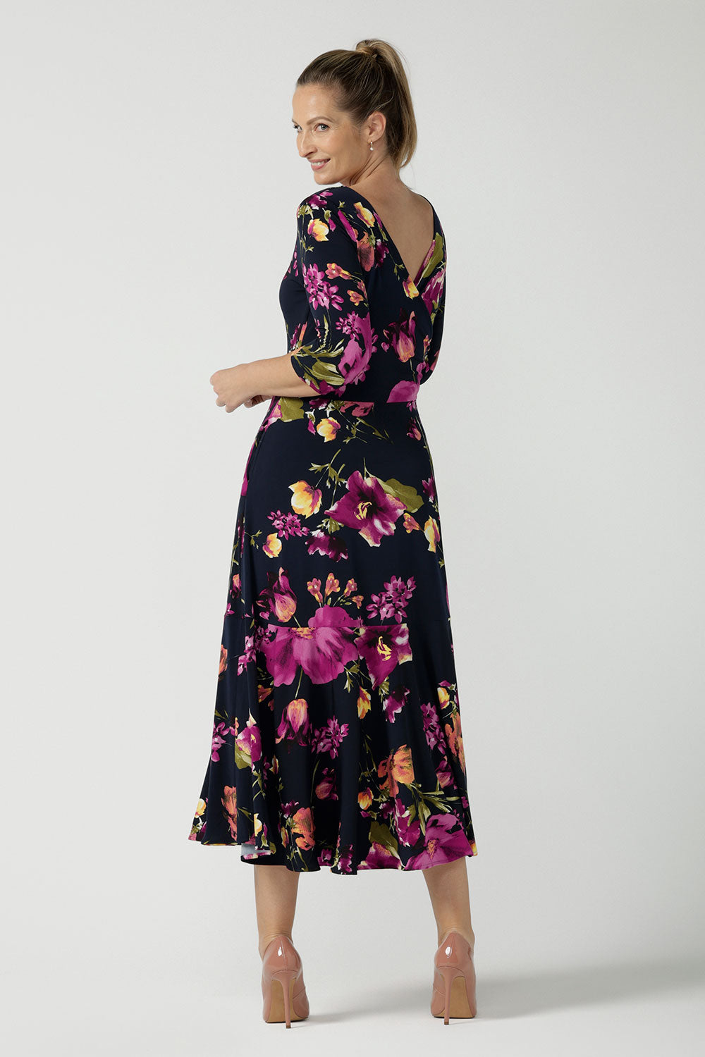 Back view of a size 10 woman wears the Bettina Reversible dress in Celeste. Fixed wrap style with pockets and v-neckline. Wear it multiple ways and reversible. Made in Australia for women size 8 - 24.