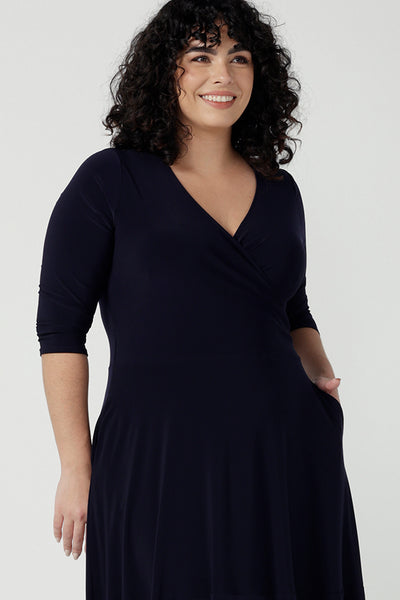 Close up of a size 18 woman wears a Bettina Reversible dress in Navy. Stylish workwear for women. Midi length with functional pockets. Made in Australia for women size 8 - 24. Soft Navy jersey fabric.