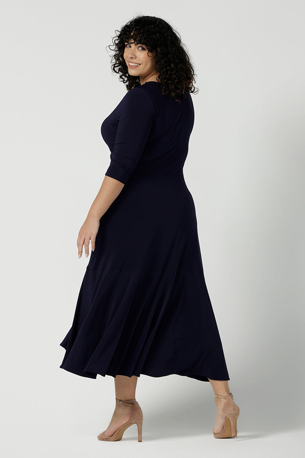 Back view of a size 18 woman wears a Bettina Reversible dress in Navy. Stylish workwear for women. Midi length with functional pockets. Made in Australia for women size 8 - 24. Soft Navy jersey fabric.