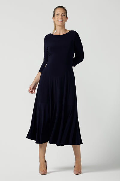 Reverse side of a size 10 woman wears a Bettina Reversible dress in Navy. Stylish workwear for women. Midi length with functional pockets. Made in Australia for women size 8 - 24. Soft Navy jersey fabric.