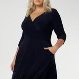 Close up of a size 18 woman wears a Bettina Reversible dress in Navy. Stylish workwear for women. Midi length with functional pockets. Made in Australia for women size 8 - 24. Soft Navy jersey fabric.