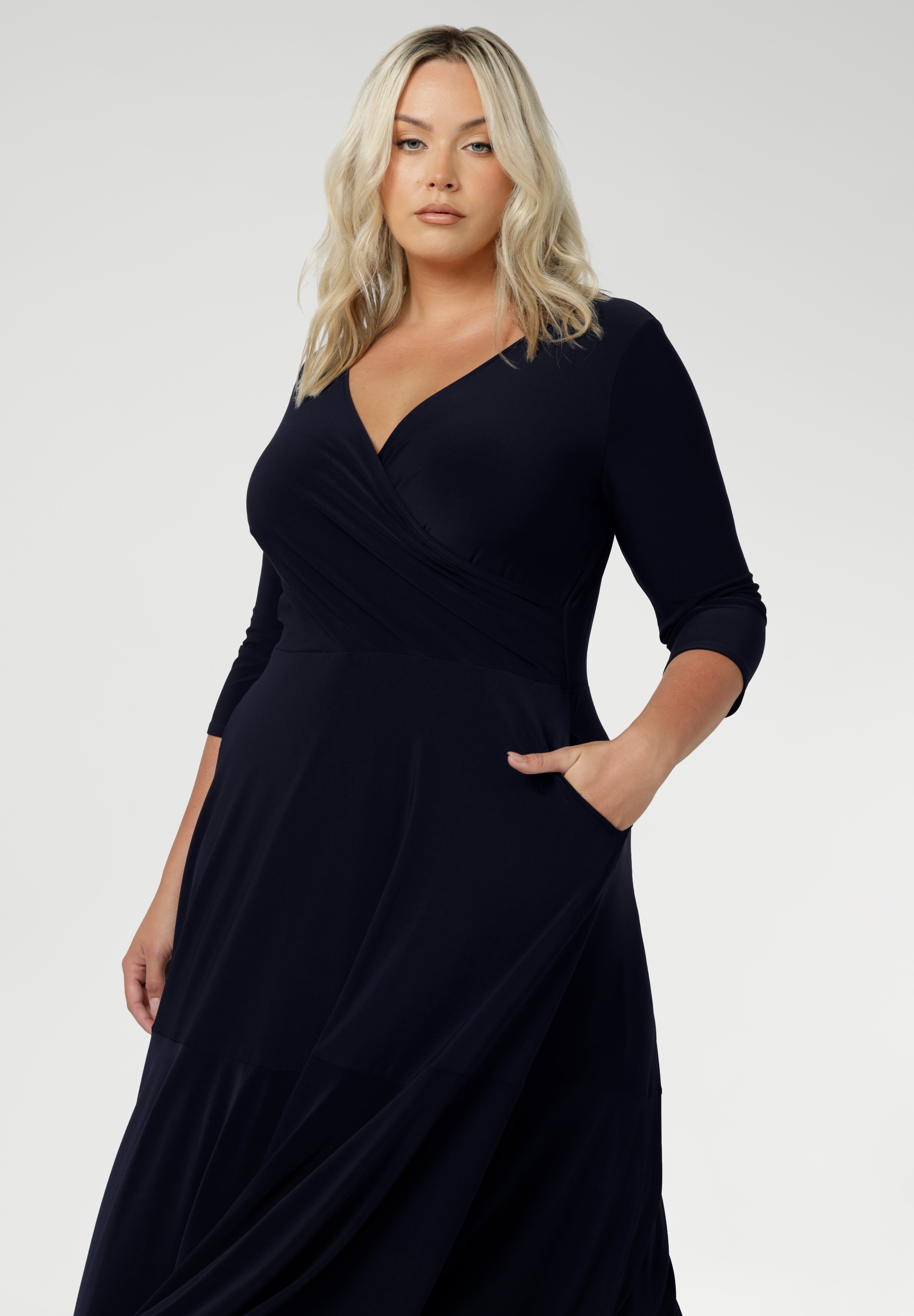 Close up of a size 18 woman wears a Bettina Reversible dress in Navy. Stylish workwear for women. Midi length with functional pockets. Made in Australia for women size 8 - 24. Soft Navy jersey fabric.