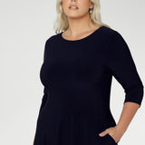 Close up of a size 18 woman wears a Bettina Reversible dress in Navy. Stylish workwear for women. Midi length with functional pockets. Made in Australia for women size 8 - 24. Soft Navy jersey fabric.