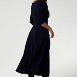 Back view of a size 10 woman wears a Bettina Reversible dress in Navy. Stylish workwear for women. Midi length with functional pockets. Made in Australia for women size 8 - 24. Soft Navy jersey fabric.