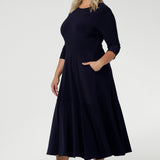Close up of a size 18 woman wears a Bettina Reversible dress in Navy. Stylish workwear for women. Midi length with functional pockets. Made in Australia for women size 8 - 24. Soft Navy jersey fabric.