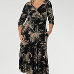 The fully reversible design offers two sophisticated neckline options: a fixed wrap V-neck on one side and a classic boat neckline with a subtle V-shaped back on the other, giving you two distinct looks in one. Size 10 woman wears reversible dress with V neck line front facing.