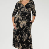 The fully reversible design offers two sophisticated neckline options: a fixed wrap V-neck on one side and a classic boat neckline with a subtle V-shaped back on the other, giving you two distinct looks in one. Size 10 woman wears reversible dress with V neck line front facing.