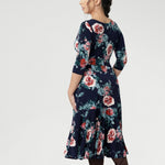 This flattering silhouette can be worn with the V-neck wrap front for a more defined, feminine shape, or reversed to feature a classic boat neckline that pairs beautifully with structured jackets or cardigans. Available in sizes 8-24 in both petite & regular sizes.