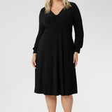 The Bianca Dress is a versatile wardrobe essential, designed to take you from work to events with effortless elegance. This classic black knee-length dress features a flattering V-neckline and a twist-front bodice that enhances your shape, while the cuffed long sleeves add a polished finish.
