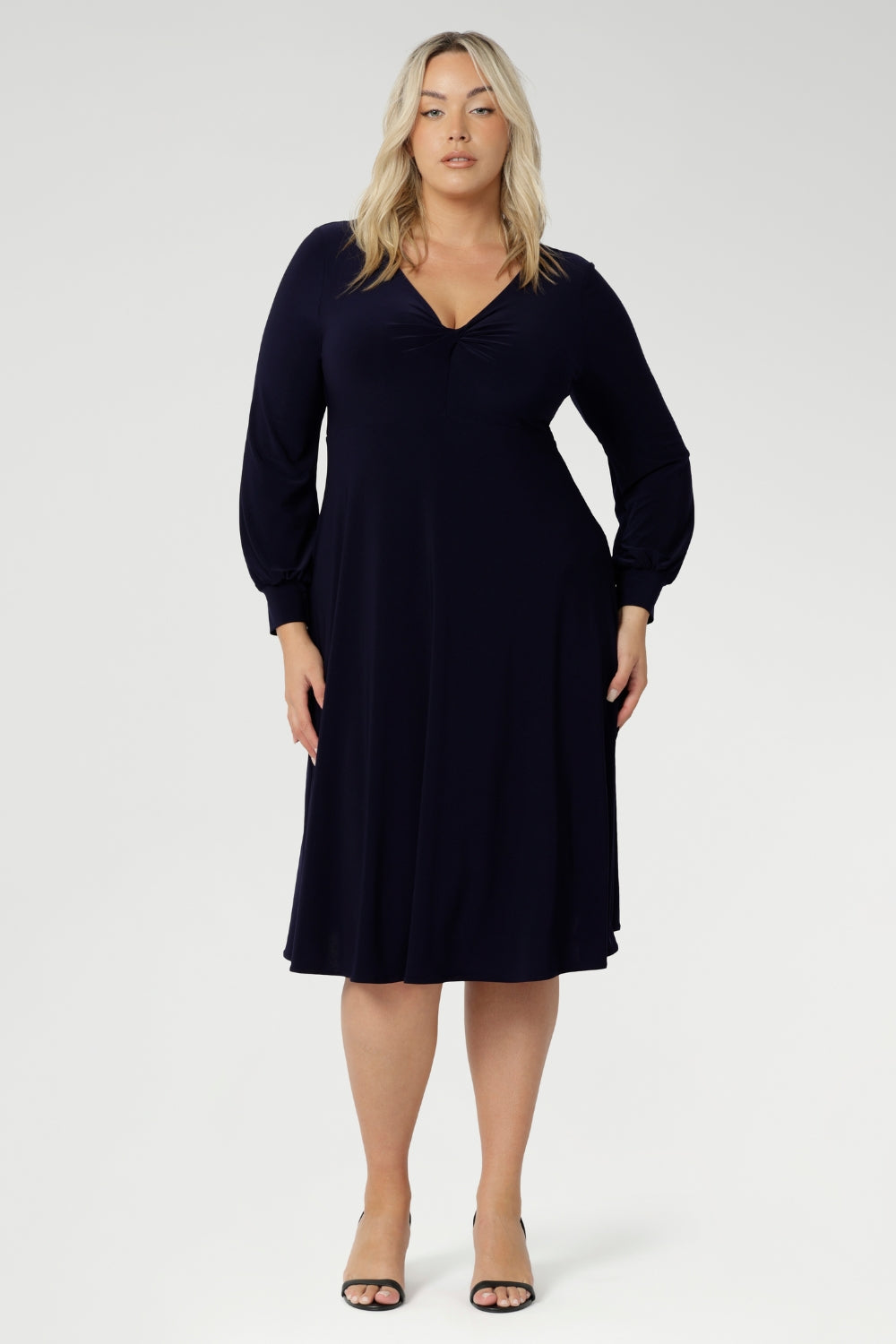Featuring a sophisticated V-neckline with a twist-front bodice and cuffed long sleeves, it creates a flattering silhouette with elegant detail. Made in Australia from our signature dry-touch jersey fabric, it offers all-day comfort, stretch, and easy care. Available in sizes 8 to 24, this versatile piece is designed to flatter petite and plus-size women alike.
