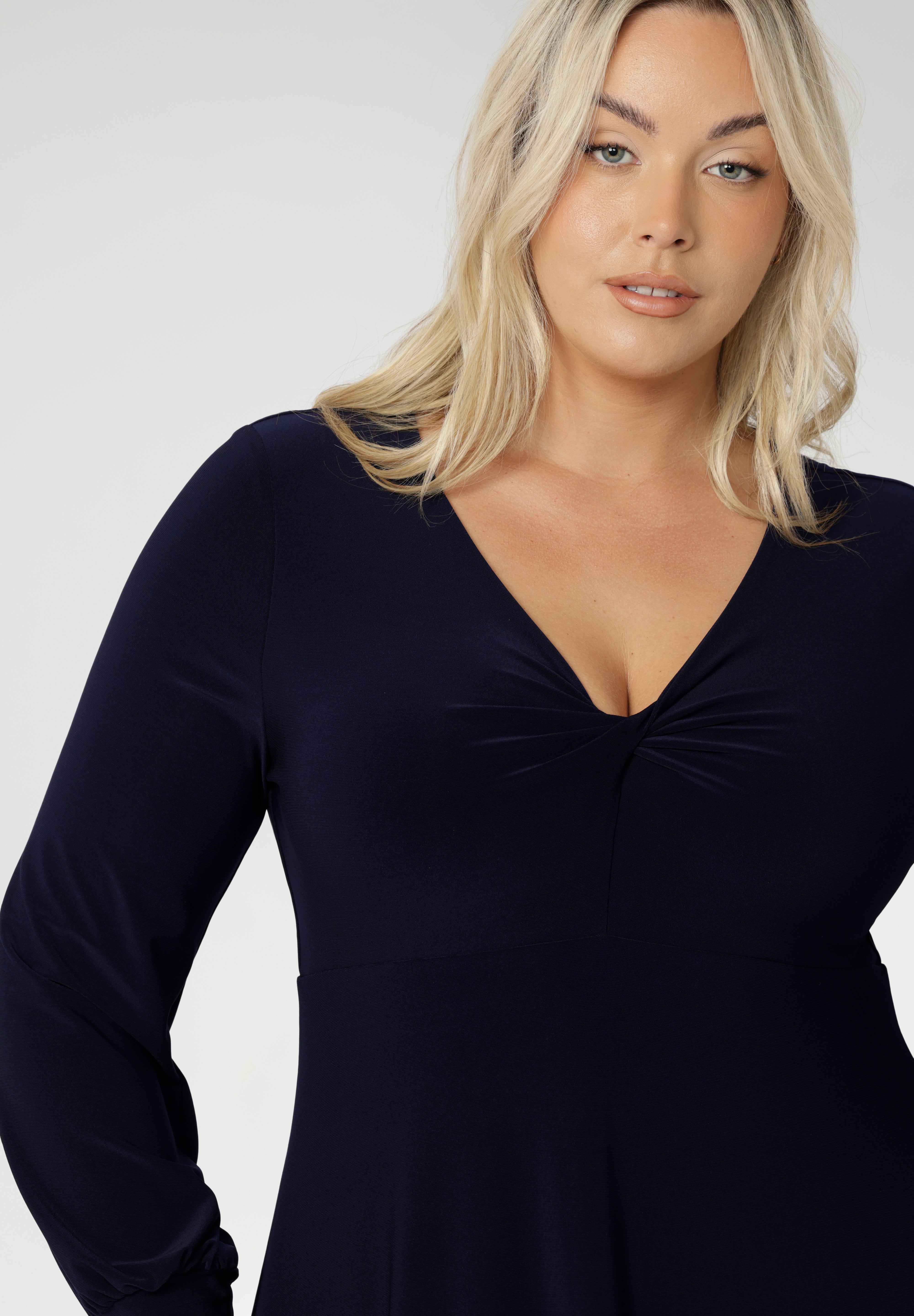 The Bianca Dress is a timeless black knee-length style designed for both work and special occasions. Featuring a sophisticated V-neckline with a twist-front bodice and cuffed long sleeves, it creates a flattering silhouette with elegant detail. Made in Australia from our signature dry-touch jersey fabric, it offers all-day comfort, stretch, and easy care.