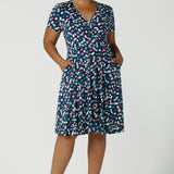 Curvy size 16 woman wears a Bubbles printed Jersey dress with a fixed wrap in a midi length. Perfect for work to weekend looks. Made in Australia for women size 8 - 24.