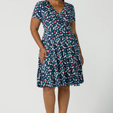 Curvy size 16 woman wears a Bubbles printed Jersey dress with a fixed wrap in a midi length. Styled back with a black heel. Perfect for work to weekend looks. Made in Australia for women size 8 - 24.