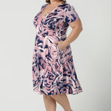 Size 18 curvy woman wearing the Alexis dress in Cantata. A navy base with pink brush strokes print. The perfect work to weekend or wedding guest outfit. Styled back with leather flats. Made in Australia for women size 8 - 24.