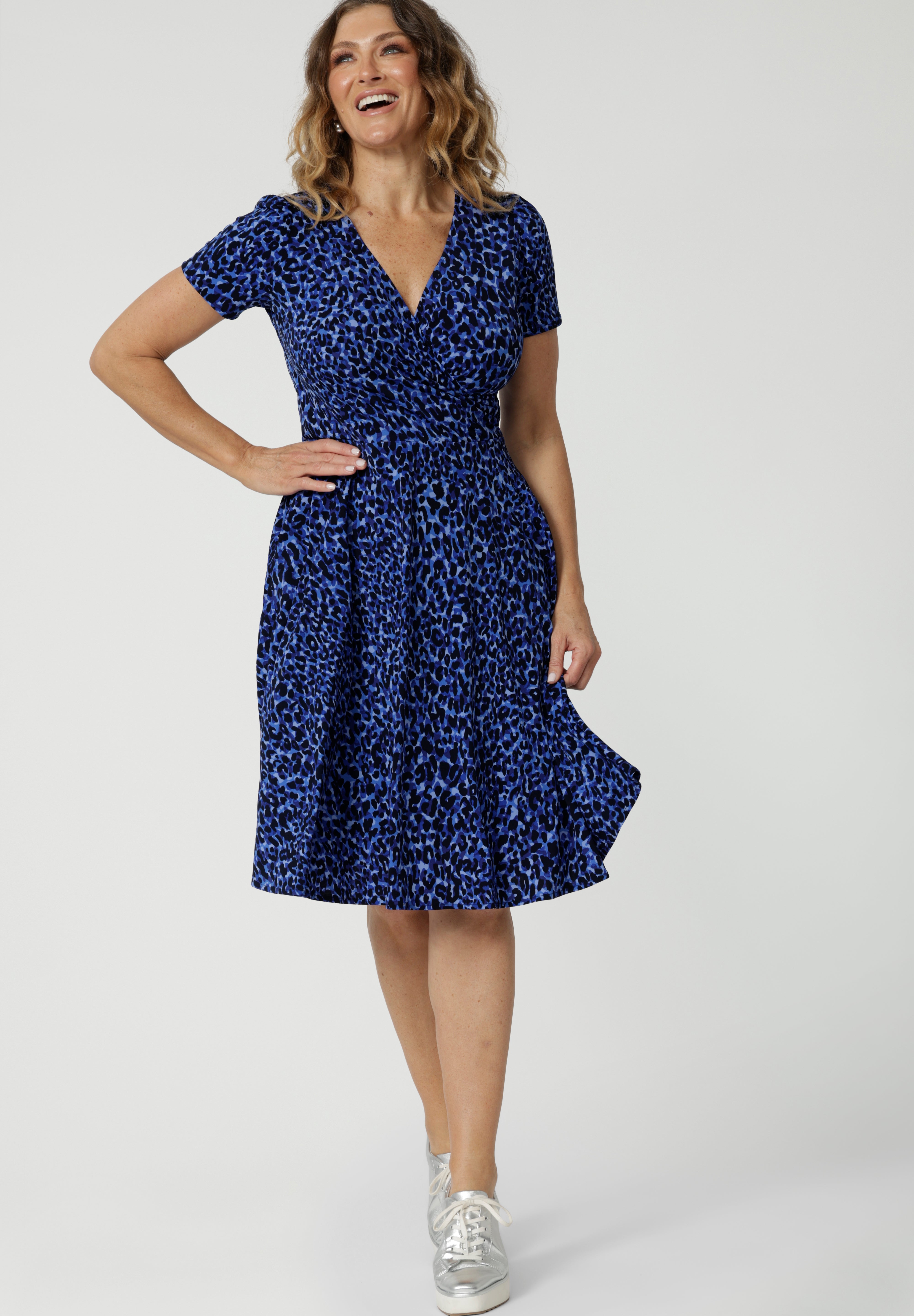 Showing a good wrap dress for summer, a woman wears a size 12, short sleeve fixed wrap dress. An animal print wrap dress with short sleeves, this is a good dress for over 50s women. Shop wrap dresses Australia online at Leina & Fleur in sizes 8-24, petite to plus sizes.