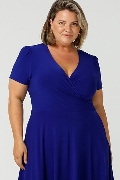 Close up of A size 18 woman wears a plus size jersey dress with short sleeves. In cobalt blue jersey, this dress is a good casual dress for weekend wear capsule wardrobes. Shop Australian-made wrap dresses for work online is sizes 8 to 24.