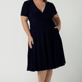 Fixed Wrap Bibi dress in Navy. Curvy size 18 woman wears a jersey dress the perfect corporate comfortable work dress. Below the knee length. Size 8 - 24. 