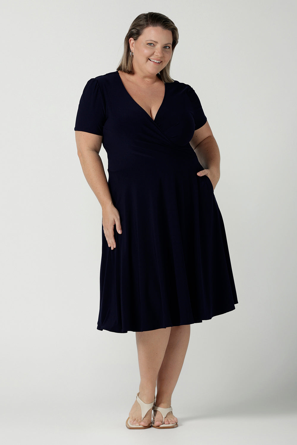 Fixed Wrap Bibi dress in Navy. Curvy size 18 woman wears a jersey dress the perfect corporate comfortable work dress. Below the knee length. Size 8 - 24. 