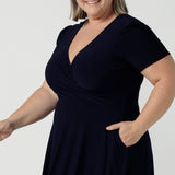 Fixed Wrap Bibi dress in Navy. Curvy size 18 woman wears a jersey dress the perfect corporate comfortable work dress. Below the knee length. Size 8 - 24.