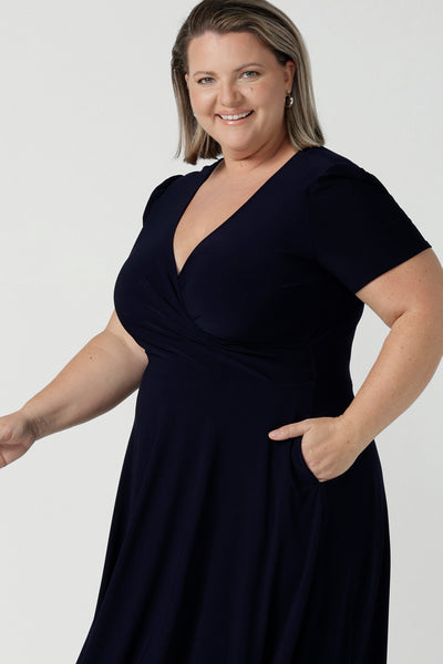 Fixed Wrap Bibi dress in Navy. Curvy size 18 woman wears a jersey dress the perfect corporate comfortable work dress. Below the knee length. Size 8 - 24.