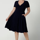 Fixed Wrap Bibi dress in Navy. Curvy size 12 woman wears a jersey dress the perfect corporate comfortable work dress. Below the knee length. Size 8 - 24.