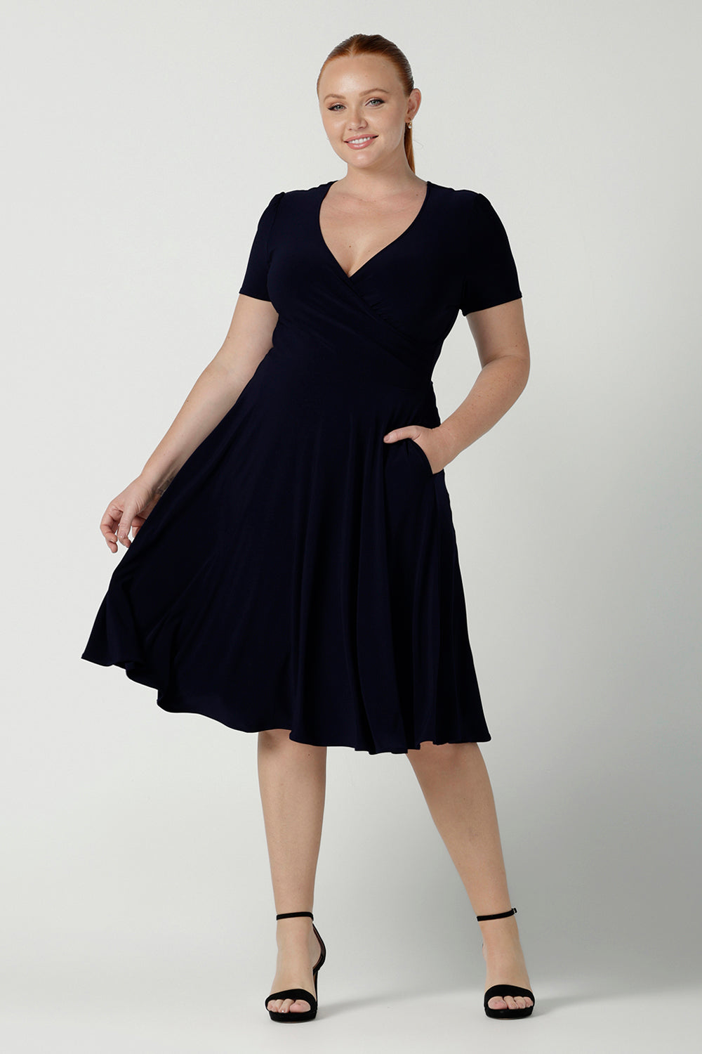 Fixed Wrap Bibi dress in Navy. Curvy size 12 woman wears a jersey dress the perfect corporate comfortable work dress. Below the knee length. Size 8 - 24.