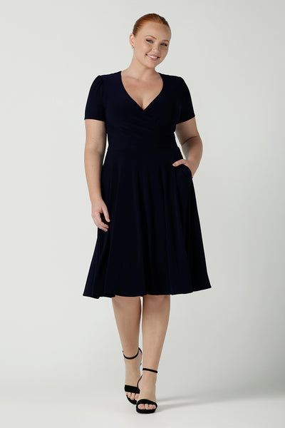 Fixed Wrap Bibi dress in Navy. Curvy size 12 woman wears a jersey dress the perfect corporate comfortable work dress. Below the knee length. Size 8 - 24.