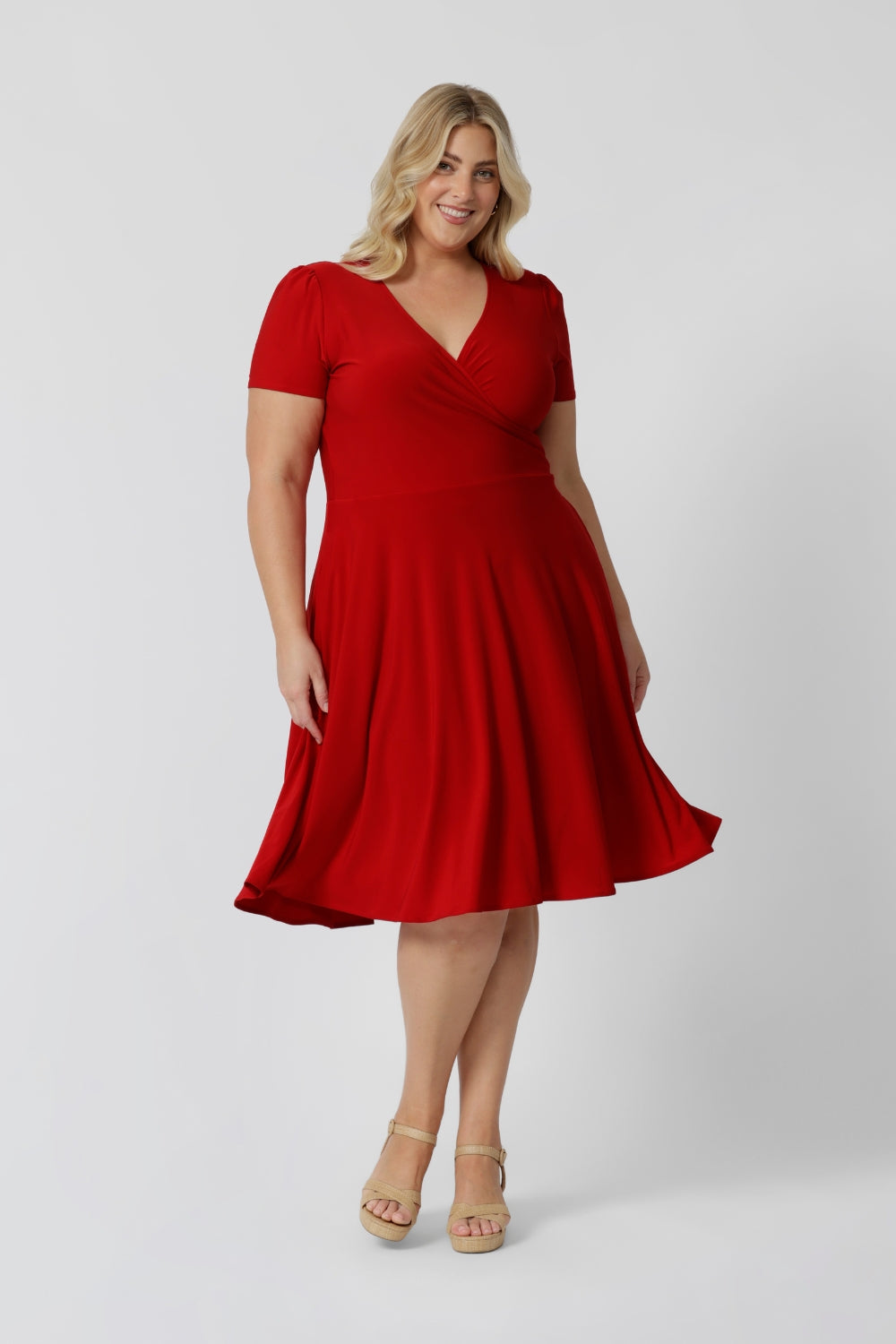 Plus sized woman wears red knee length dress made of cooling dry touch jersey fabric. Capturing the essence of the season, this sleeved dress is designed for women by woman in Australia and New Zealand. Available in sizes 8 to 24. Leina & Fleur ensure that there is a flattering fit for all.