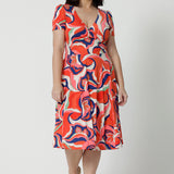 The best fixed wrap dress for petite height women, the Bibi Wrap Dress is new in Tangerine, Red, White, Mint Green and Purple retro print. Shown on a petite woman, this summer wrap dress is a fit and flare style with full, knee length skirt and pockets. Easy-care, it's a good dress for travel and cruise wear. Made in Australia by Australian and New Zealand women's clothes brand Leina & Fleur.