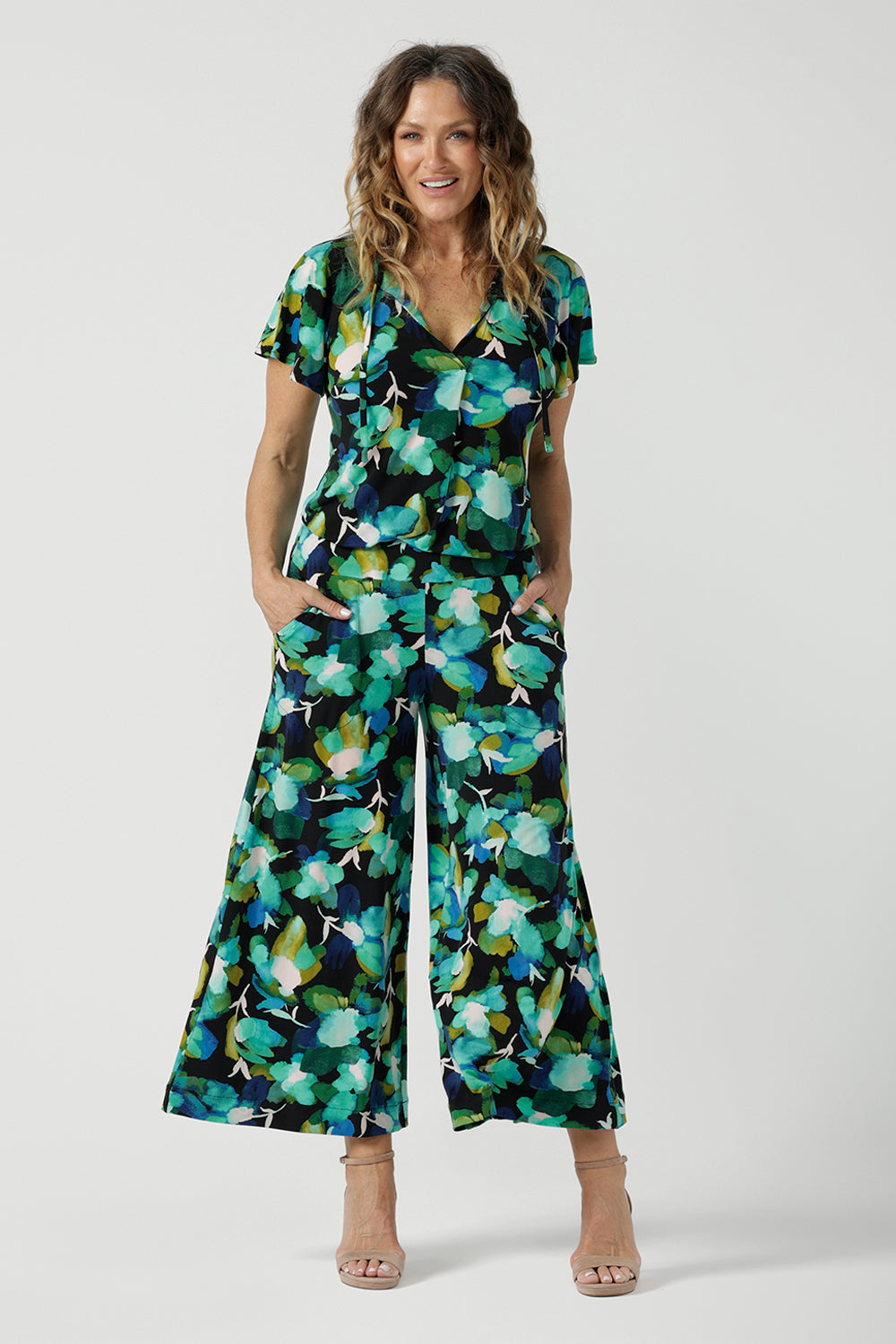 Size 12 woman wears the Dany culotte in Canopy, a wide leg culotte with the canopy print. A bold green colour splatter print. Styled back with nude heels and the Bowie Top in Canopy. Made in Australia for women size 8 - 24. 