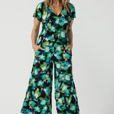 Size 12 woman wears the Dany culotte in Canopy, a wide leg culotte with the canopy print. A bold green colour splatter print. Styled back with nude heels and the Bowie Top in Canopy. Made in Australia for women size 8 - 24. 