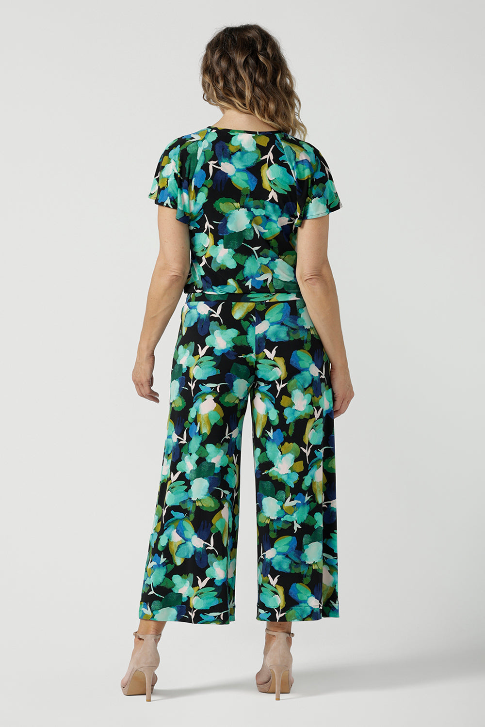 Size 12 woman wears the Dany culotte in Canopy, a wide leg culotte with the canopy print. A bold green colour splatter print. Styled back with nude heels and the Bowie Top in Canopy. Made in Australia for women size 8 - 24. 