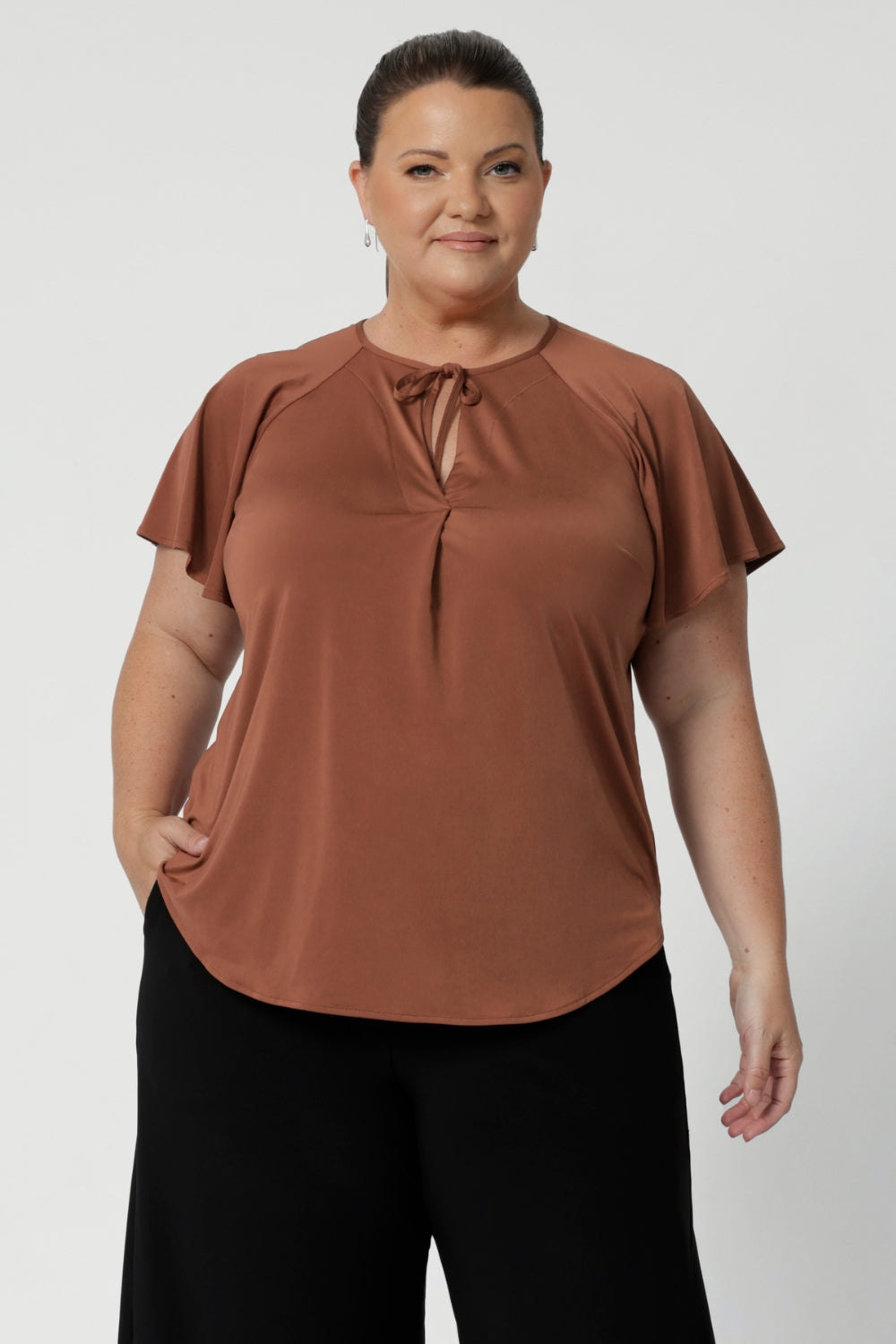 The shirttail hemline gives the top a clean, contemporary finish, making it easy to pair with trousers, skirts, or even jeans for a more casual day at work.