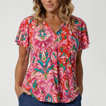 Close up image of 40 year old woman wears flutter sleeved summer printed blouse, featuring v neckline, shirt tail hemline & short flutter sleeves. Made from easy care and lightweight crepe jersey, that is breathable and comfortable. Leina & Fleur proudly stock petite and plus sizes 8-24.