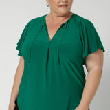 A great summer top for women, this jade green jersey top has flutter sleeve and a v-neckline. Tie neck with a curved hem. A workwear friendly comfortable style for women. Size inclusive and made in Australia for women 8-24. 