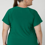 A workwear friendly comfortable style for women. Size inclusive and made in Australia for women 8-24. Plus sized model wears jade green coloured top with classic black work pants.