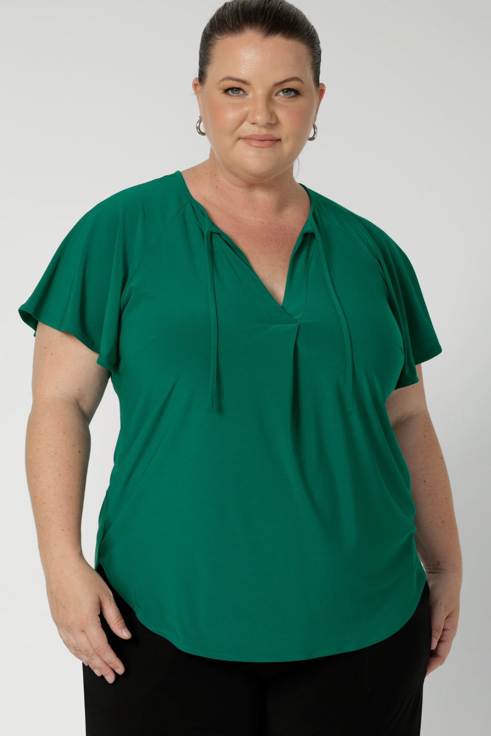 A great summer top for women, this jade green jersey top has flutter sleeve and a v-neckline. Tie neck with a curved hem. A workwear friendly comfortable style for women. Size inclusive and made in Australia for women 8-24. 