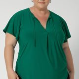 A great summer top for women, this jade green jersey top has flutter sleeve and a v-neckline. Tie neck with a curved hem. A workwear friendly comfortable style for women. Size inclusive and made in Australia for women 8-24. 