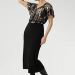 Size 10 woman wears a leopard print top with black midi skirt and black high-heeled boots creating an elegant outfit for everyday.