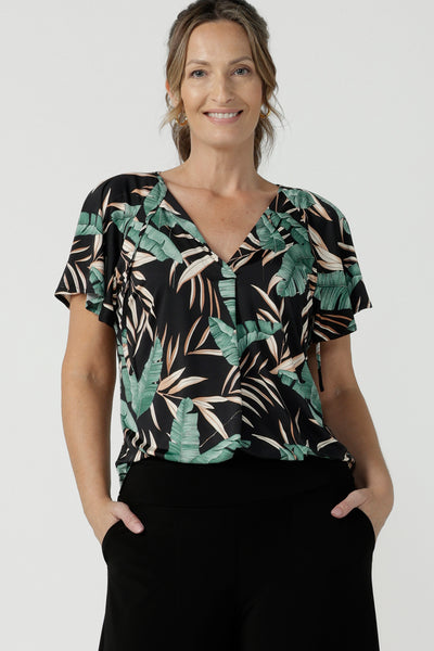 A flutter raglan sleeve jersey top. Featuring a beautiful tropical print on a black background. Lightweight jersey cool to touch and easy care.