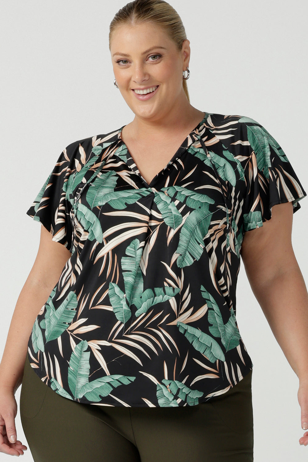 A flutter raglan sleeve jersey top with a flutter sleeve. Featuring a beautiful tropical print on a black background. Lightweight jersey cool to touch and easy care. Size inclusive fashion.