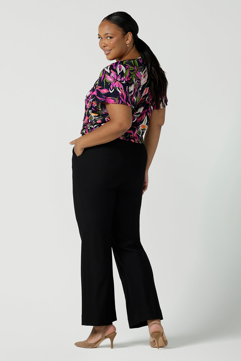Back view of a size 16 Woman wears the Brett Pant in black, a soft tailored ponte jersey pant with a slight kick flare at the bottom. Made in Australia for women size 8 - 24.