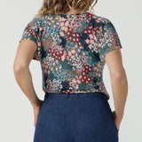 Back view of a size 10 woman wears the Bowie Top in jersey with flutter sleeves and tick neckline. Styled back with Denim Pants. Made in Australia for women size 8-24. 