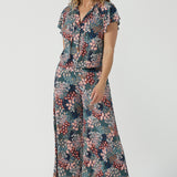 Close up of a size 10 woman wears the Presley Pant in Whimsy, a wide leg pant with a Whimsy print. A made in Australia wide leg pant with a ditsy floral print print. Size inclusive fashion for women size 8-24. Styled back with a Bowie Top in soft and comfortable jersey. 