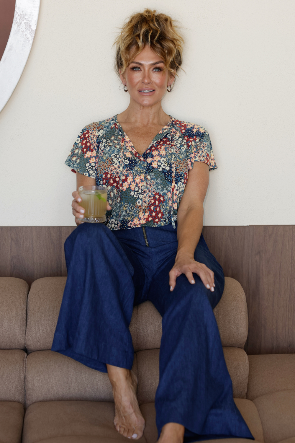 A size 10 woman wears the Bowie Top in jersey with flutter sleeves and tick neckline. Styled back with Denim Pants. Made in Australia for women size 8-24. 