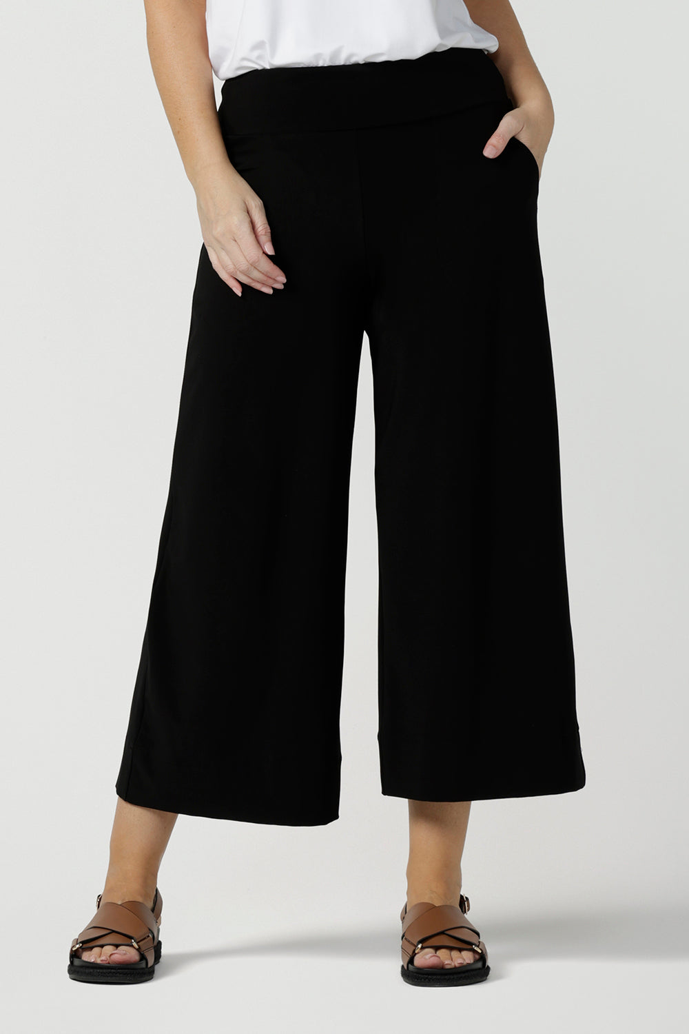 Comfortable, wide leg black culotte pants are worn with a V-neck white bamboo jersey top with short sleeves. Cropped pants with pockets, these pull-on casual trousers are made in Australia by women's clothing brand, Leina & Fleur - size inclusive, shop online in petite, mid size and plus sizes.